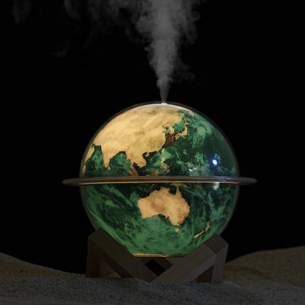 Glowing Earth humidifier diffuser in green light with steam mist at night